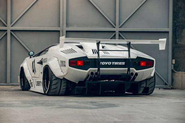 Rear 3/4 view of a white Lamborghini Countach with Liberty Walk body kit